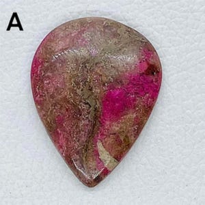 May include: A pink and brown heart-shaped stone with a marbled pattern.