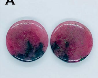 Puede incluir: Un par de pendientes redondos de piedra preciosa rosa y negra. Los pendientes tienen un patrón de mármol.