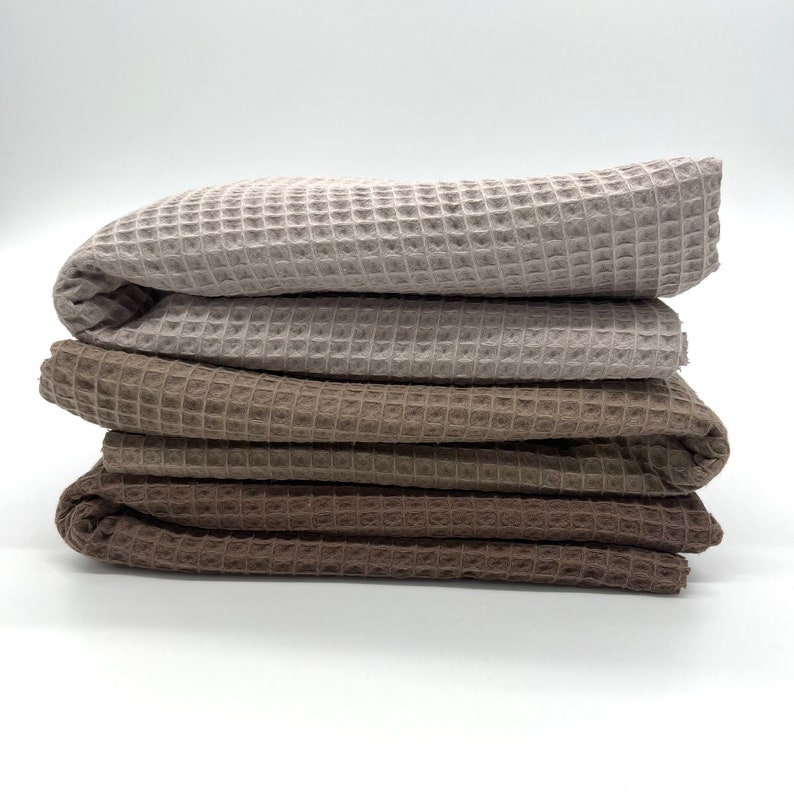 May include: Four waffle weave towels stacked on top of each other. The towels are in shades of brown and beige.