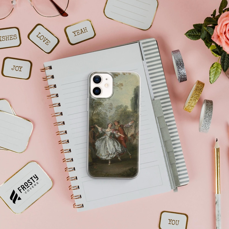 Pode incluir: Uma capa de telefone transparente com uma pintura cl&aacute;ssica de um casal dan&ccedil;ando em um jardim. A capa est&aacute; em um caderno espiral com detalhes dourados, cercada por adesivos decorativos e artigos de papelaria.