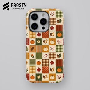 May include: A phone case featuring a patchwork grid design with autumn-themed illustrations including orange pumpkins, brown acorns, red maple leaves, green and white checkered patterns, and floral motifs in shades of orange, green, and brown.