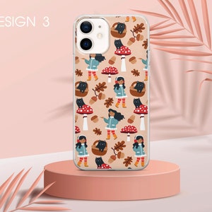 May include: A phone case with a design featuring a repeating pattern of mushrooms, black cats, and girls wearing blue jackets and earmuffs. The background is a light brown colour.