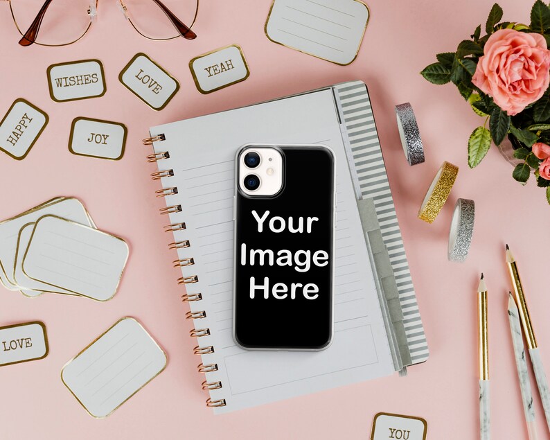 Może przedstawiać: Czarne etui na iPhone'a z białym obramowaniem i obiektywem aparatu. Na etui widnieje napis "Your Image Here". Etui leży na r&oacute;żowym tle obok notesu, oł&oacute;wk&oacute;w i ozdobnej taśmy washi.