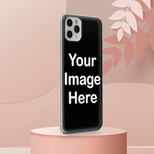 Może przedstawiać: Czarne etui na telefon z białą ramką i wycięciem na obiektyw aparatu. Na etui widnieje napis "Your Image Here". Etui na telefon leży na r&oacute;żowym cokole.