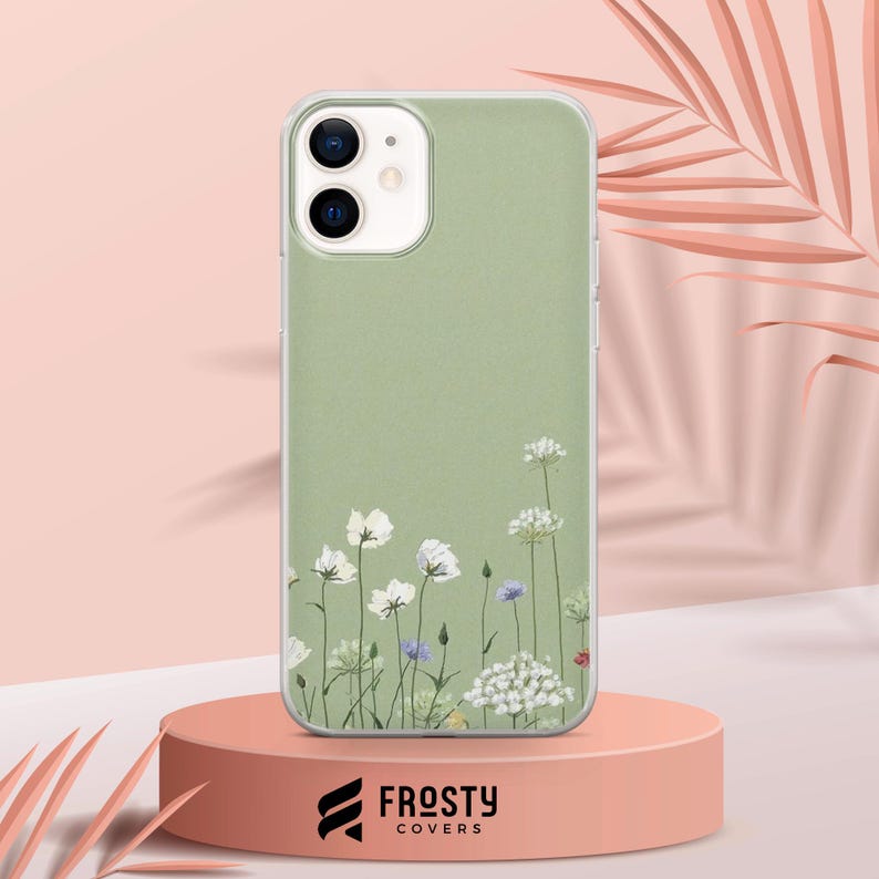 K&ouml;nnte beinhalten: Eine gr&uuml;ne Handyh&uuml;lle mit einem wei&szlig;en Blumenmuster. Die H&uuml;lle ist aus klarem Kunststoff und hat eine matte Oberfl&auml;che. Die Blumen sind vertikal angeordnet und mit kleinen blauen und violetten Blumen verziert.