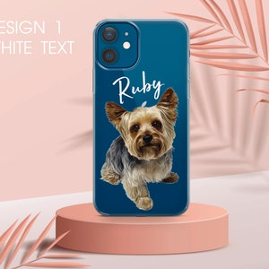 Pu&ograve; includere: Una custodia per telefono blu con un ritratto di cane Yorkshire Terrier e il nome "Ruby" in scrittura bianca. La custodia ha il testo "DESIGN 1 WHITE TEXT" in alto a sinistra. Il cane ha peli marroni e neri.