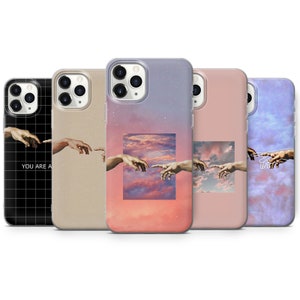 Può includere: Una collezione di cinque custodie per telefono con l'opera d'arte "Creazione di Adamo". Le custodie presentano l'immagine con vari sfondi, tra cui una griglia, beige, un tramonto e un cielo nuvoloso. Una custodia ha il testo "YOU ARE A".