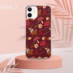 May include: A phone case with a red background and a pattern of deer, mushrooms, and leaves. The case is clear and shows the phone's camera lens.