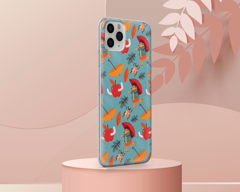 May include: A clear phone case with a blue background and a repeating pattern of red apples, yellow leaves, brown bugs, and people wearing red umbrellas.