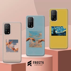 May include: Three smartphone cases featuring artistic prints. The left case is beige with cherubs in clouds. The center case is light blue with a depiction of reaching hands in the sky. The right case is yellow with a starry night landscape print.