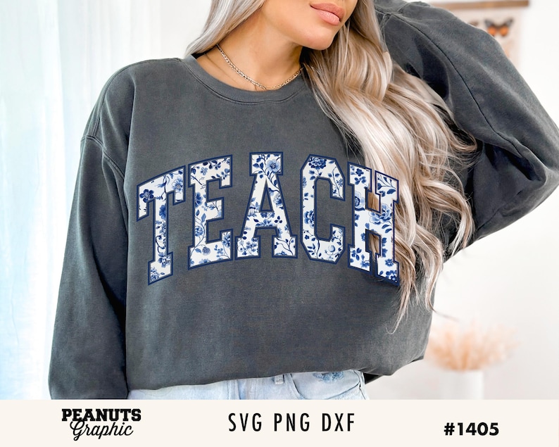 May include: A dark gray sweatshirt with the word "TEACH" printed in white letters with a blue floral pattern.