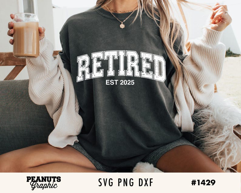 May include: A dark gray t-shirt with the text "Retired Est 2025" in white lettering. The shirt is being worn by a person.