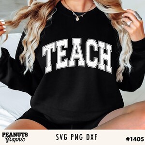 May include: A black sweatshirt with the word "TEACH" in white distressed lettering. The sweatshirt is worn by a person with long blonde hair.