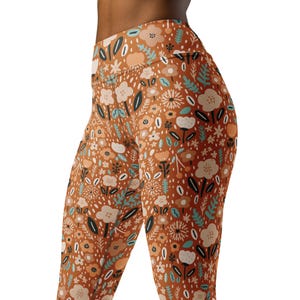 May include: Brown leggings with a floral print featuring a variety of flowers, leaves, and dots in shades of brown, cream, teal, and black.