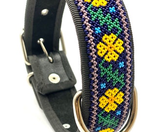 May include: A black dog collar with a beaded design featuring yellow, green, blue, and purple flowers. The collar has a silver metal buckle and D-ring.