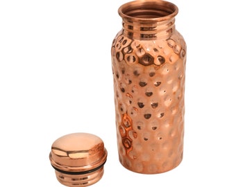 May include: A hammered copper water bottle with a matching lid. The bottle has a traditional design and is perfect for carrying water on the go.