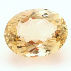 Puede incluir: Una piedra preciosa ovalada de color amarillo claro con un corte facetado.