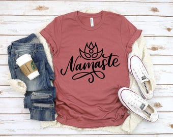 May include: A dusty rose t-shirt with a black graphic of a lotus flower and the word "Namaste".