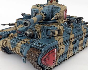 Può includere: Un modello dettagliato di carro armato in blu, beige e rosso. Il carro armato presenta una canna di grosso calibro, più torrette e dettagli intricati. Il modello è ambientato su uno sfondo bianco.