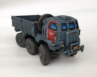 May include: A detailed model of a gray military truck with six wheels. The truck features a red stripe on the side and a spare tire mounted on the back. The windows have a blue sky painted inside.
