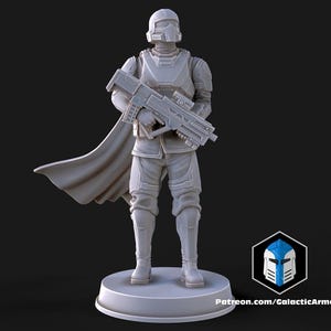 May include: A gray, futuristic soldier figurine holding a rifle, with a cape and helmet. The figure is standing on a round base. The text "Patreon.com/GalacticArmory" is visible.