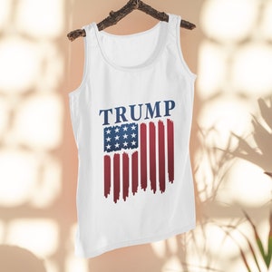 May include: White tank top with a blue and red American flag design and the word "TRUMP" printed in blue.