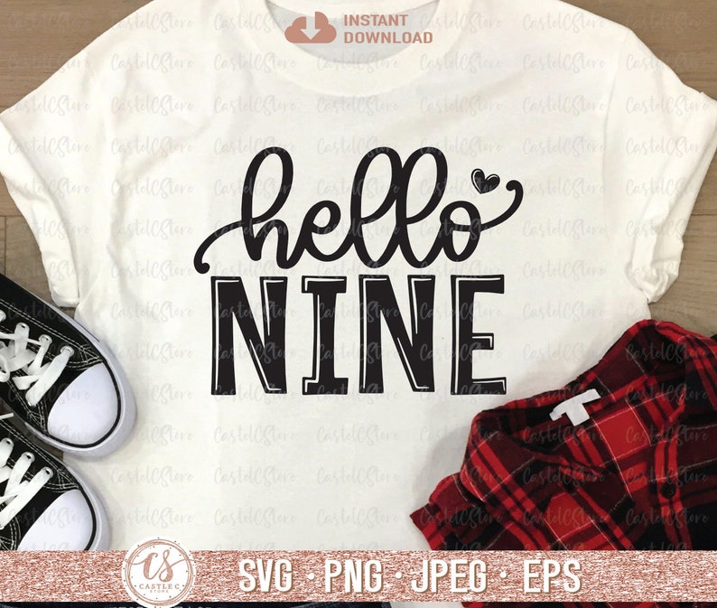Puede incluir: Una camiseta blanca con texto negro que dice "hello nine" con un peque&ntilde;o coraz&oacute;n sobre la palabra "hello".