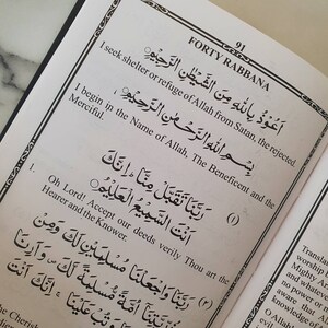 May include: A page from a book containing Arabic text and an English translation. The text is from the Quran, a holy book in Islam. The page is titled "Forty Rabbana" and includes the Arabic text for the 40th chapter of the Quran, along with an English translation.