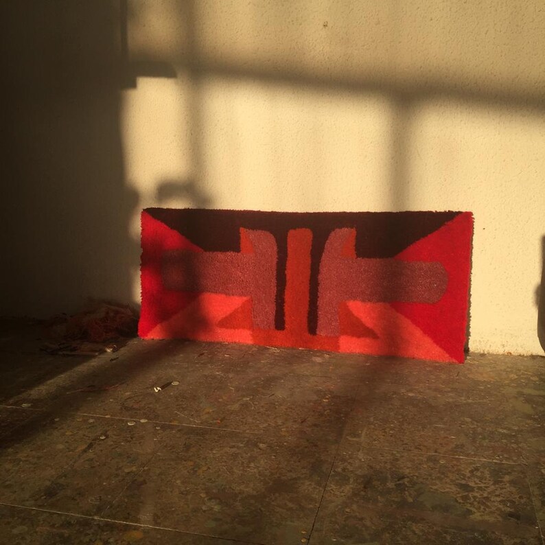 Pu&ograve; includere: Un tappeto geometrico rosso, marrone e rosa con un design moderno. Il tappeto &egrave; realizzato in un materiale spesso e testurizzato e presenta un motivo astratto unico.