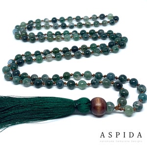 May include: A green agate mala necklace with a wooden bead and a green tassel. The necklace is made of 108 beads and is approximately 18 inches long.