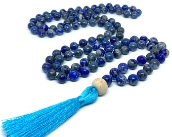 May include: A blue lapis lazuli mala with a wooden bead and a turquoise tassel. The mala is made of 108 beads and is used for meditation and prayer.