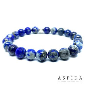 Puede incluir: Un brazalete de piedras preciosas azules y grises con un cierre plateado. El brazalete está hecho de cuentas redondas y tiene una longitud aproximada de 20 cm.