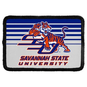May include: A rectangular patch with a black stitched border featuring the Savannah State University logo. The design includes a snarling orange and black tiger over a blue and white striped background with the text SAVANNAH STATE UNIVERSITY.