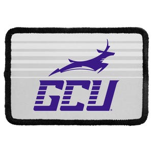 May include: A rectangular patch with a black stitched border featuring a white background with horizontal light gray stripes. The design includes a purple leaping antelope graphic positioned above the bold purple text GCU in a stylized font.