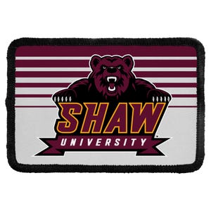 May include: A rectangular embroidered patch with a black stitched border. The design features a maroon bear mascot above the text SHAW UNIVERSITY in yellow and maroon lettering, set against a background of horizontal maroon and white stripes.