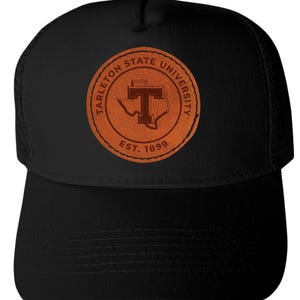 May include: Black trucker hat featuring a brown leather patch with the words "Tarleton State University" and "Est. 1899." The patch includes a stylized "T" and the outline of Texas. The hat has a curved brim and mesh back.