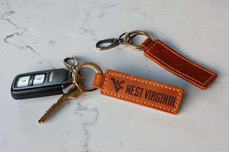 two leather keychains with two keys attached to them