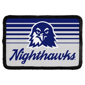 May include: A rectangular patch with a black stitched border. The design features a dark blue eagle head graphic centered above the text Nighthawks in a dark blue script font. The background consists of horizontal dark blue and white stripes.