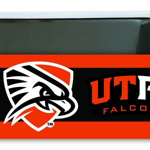 May include: A black and orange magnet with a white falcon logo and the text "UTPB FALCONS TM".