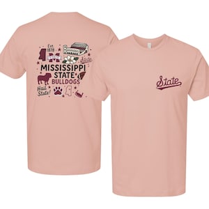 May include: A light pink short-sleeve t-shirt featuring a maroon and white graphic on the back with the text Mississippi State Bulldogs, Est. 1878, and Hail State, alongside icons of a bulldog, football, stadium, and flower. The front has the word State.