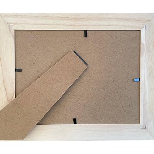 a picture frame with a piece of cardboard sticking out of it
