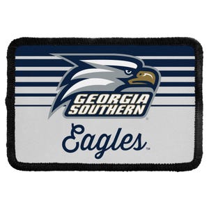 May include: A rectangular patch with a black stitched border featuring a navy blue and white striped background. It displays a stylized eagle head logo above the text GEORGIA SOUTHERN in navy blue, followed by the word Eagles in a navy blue script font.