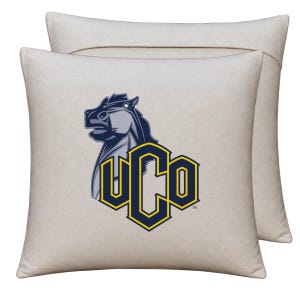 May include: Two square off-white throw pillows featuring a graphic of a horse head in shades of blue and grey, positioned above the letters UCO in bold blue font with a yellow outline. The design is centered on the front of the pillows.