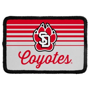 May include: A rectangular patch with a black stitched border. The top half features red and white horizontal stripes, while the bottom half is solid white. A red paw print logo with the letters SD and the word Coyotes in red script are centered.