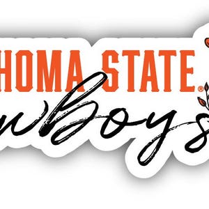 May include: A white sticker with the words "OKLAHOMA STATE Cowboys" in orange and black script. A floral design with orange flowers and brown stems is on the right side of the sticker.