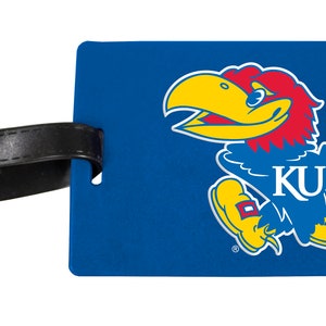 May include: Blue luggage tag with a yellow and red mascot of a bird with the text "KU" on its chest.