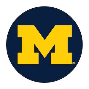 May include: A navy blue circle with a large yellow letter "M" in the center. The "M" is a bold, blocky design. A small registered trademark symbol is in the lower right corner of the circle.
