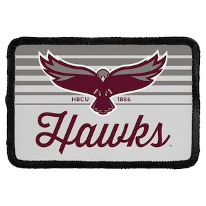 May include: A rectangular patch with a black stitched border featuring a light gray background with horizontal dark gray stripes. A maroon and gray hawk graphic is centered above the text HBCU 1886 and the word Hawks in a maroon script font.