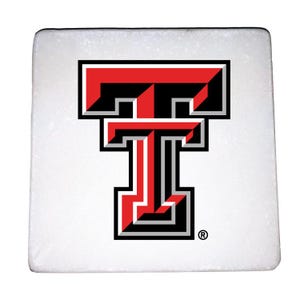 May include: White square coaster with a red and black Texas Tech University logo. The logo is a stylized "T" with a red outline and black fill.