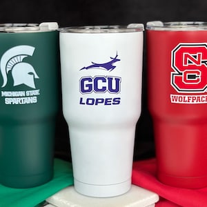 three different colored tumblers sitting next to each other
